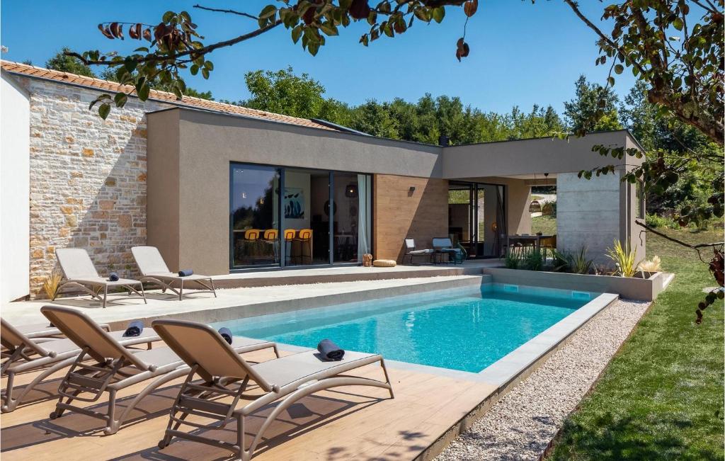 a swimming pool with chairs and a house at Villa Zel in Lovrinići