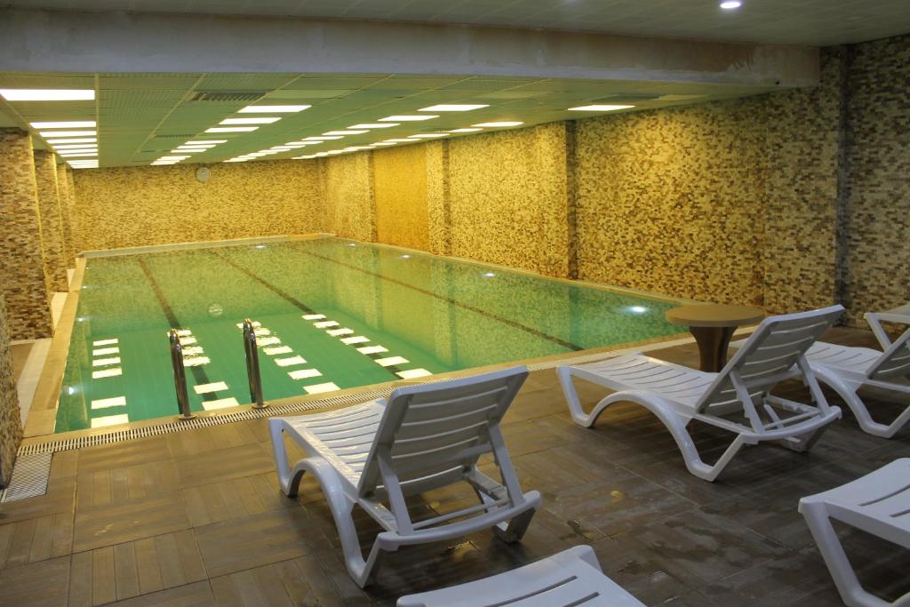 une piscine avec des chaises longues et une piscine dans l'établissement Grand Alin Otel, à Turhal