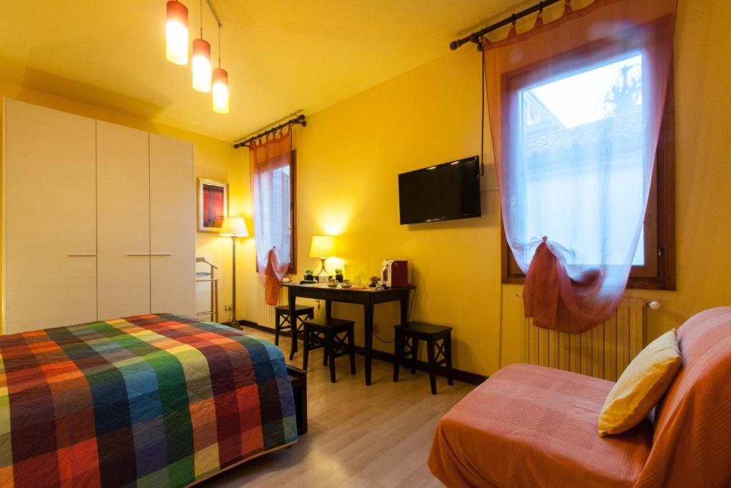 a room with two beds and a table with a window at B&B Da Nina Venice in Venice