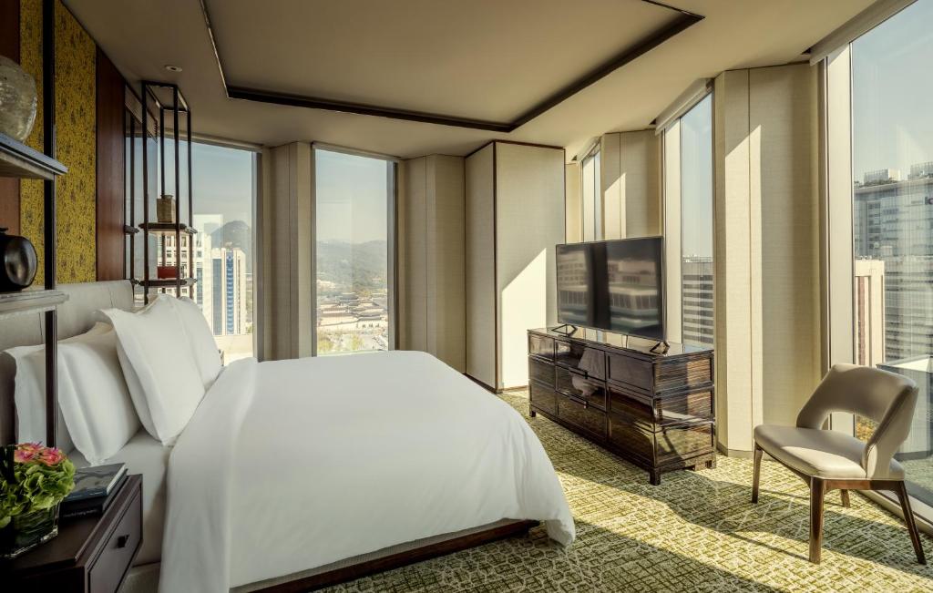 a bedroom with a white bed and a large window at Four Seasons Hotel Seoul in Seoul