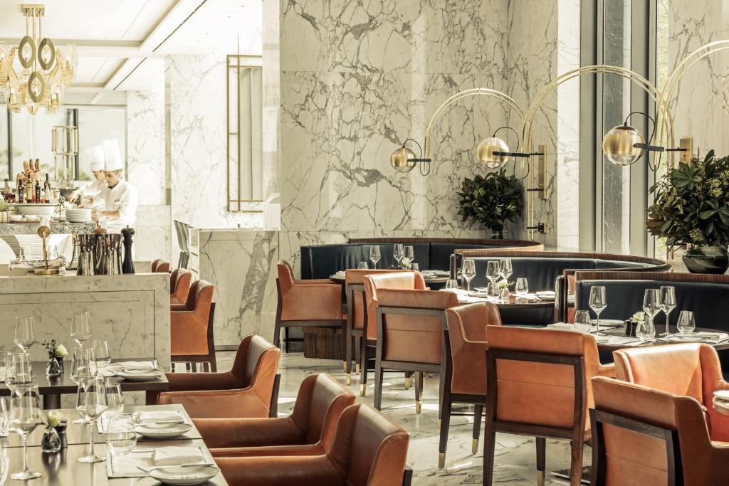 a restaurant with tables and chairs and a chef in the background at Four Seasons Hotel Seoul in Seoul