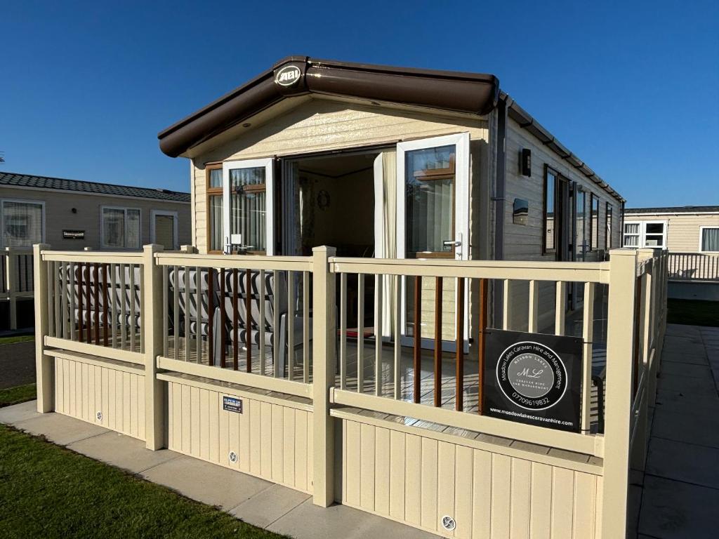 ein Haus mit einem Tor und einem Zaun in der Unterkunft The Retreat 34, Central Heating, Pet friendly, WiFi - Golden Palm Resort - Meadow Lakes Caravan & Lodge Hire in Chapel Saint Leonards