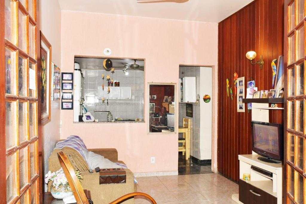 a living room with a couch and a tv at Casa com Quarto Duplo com Banheiro Privativo in Rio de Janeiro