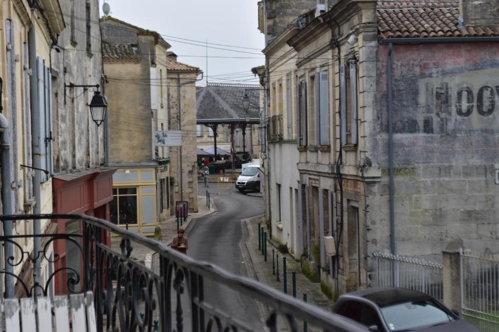 une rue urbaine avec des bâtiments et une voiture en bas de la rue dans l'établissement Appartement de caractère plein centre, à Bourg
