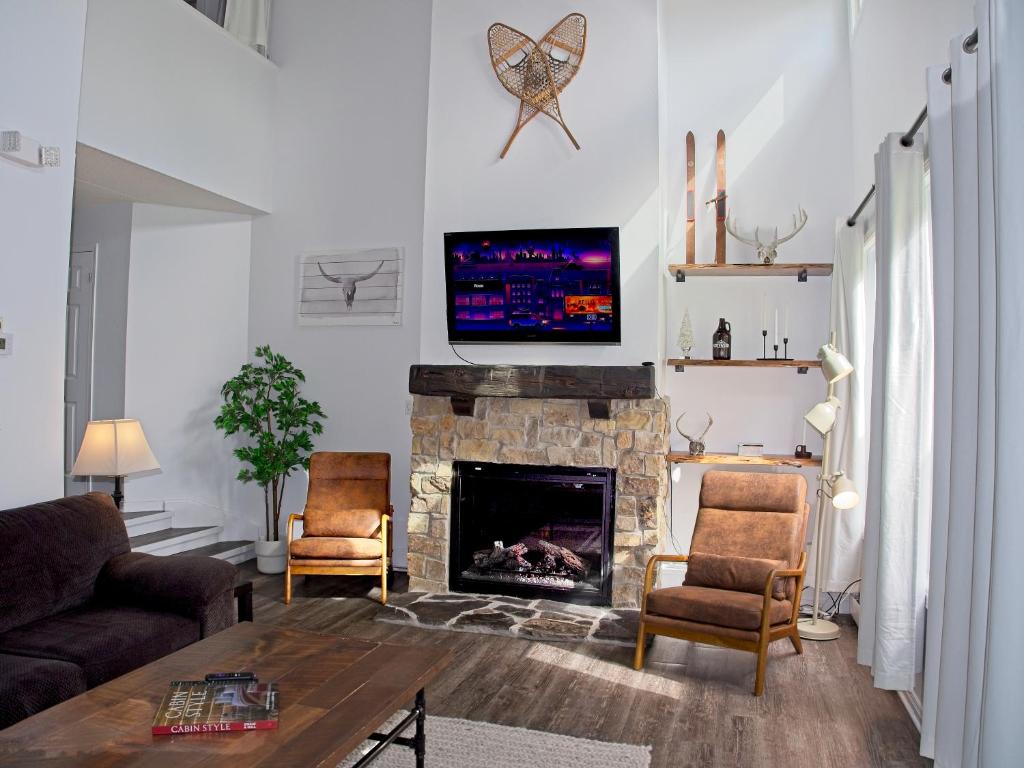 a living room with a fireplace with a tv above it at Modern Town at Wintergreen 2min walk to Village Sauna in Blue Mountains