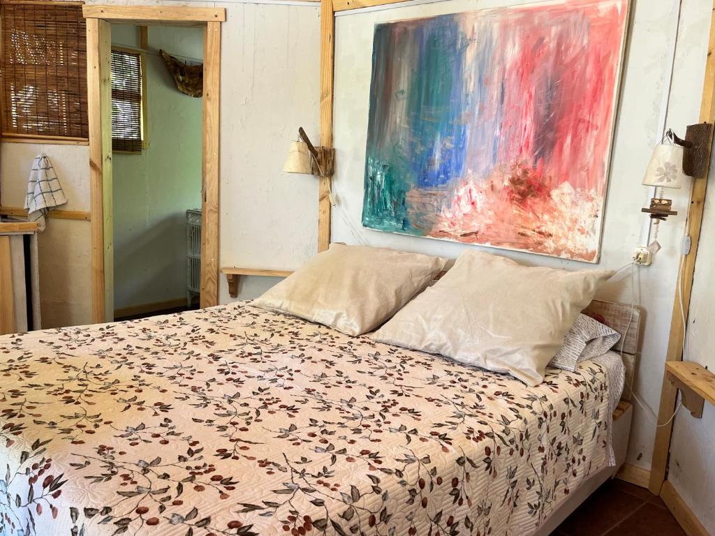 une chambre avec un lit et un tableau au mur dans l'établissement Cabaña Rústica en Cochiguaz, à El Sanjeado