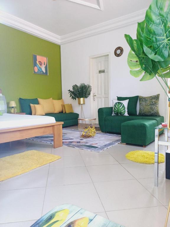 ein Wohnzimmer mit grünen Wänden und einem Sofa in der Unterkunft Résidence Meublée Pachira I in Abidjan