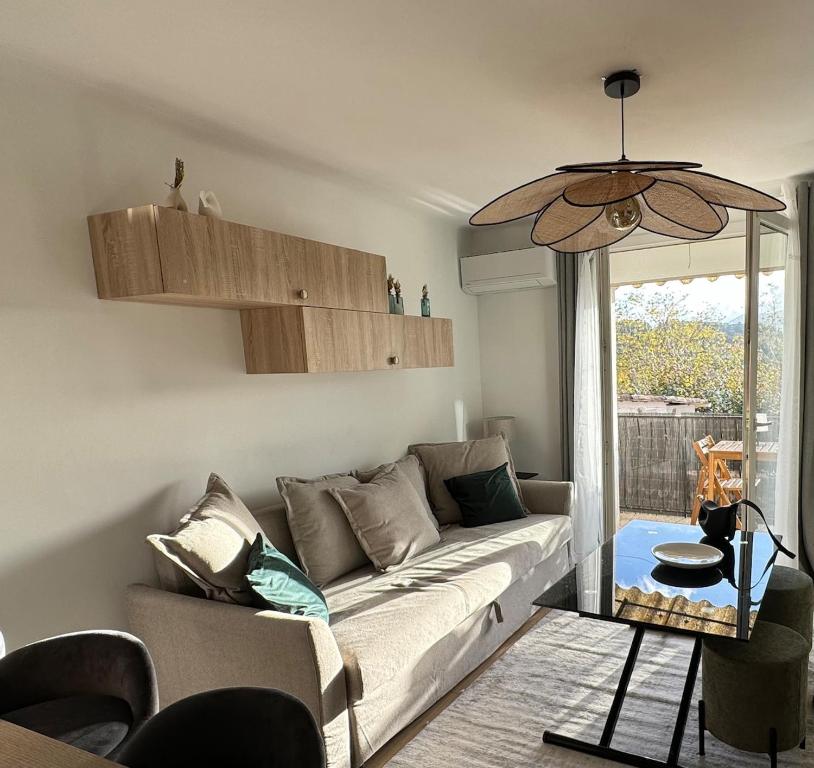 un salon avec un canapé et une fenêtre dans l'établissement Cosy cottage by Alice Maison de village provençal, à Fuveau