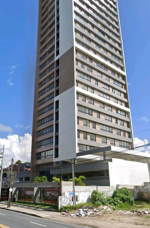 a large tall building with a bus in front of it at Loft Alto Padrão Um Quarto in Recife