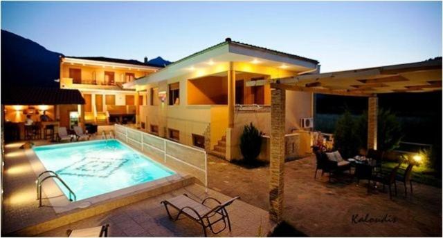 a house with a swimming pool in front of it at Apartments Giota in Chrysi Ammoudia