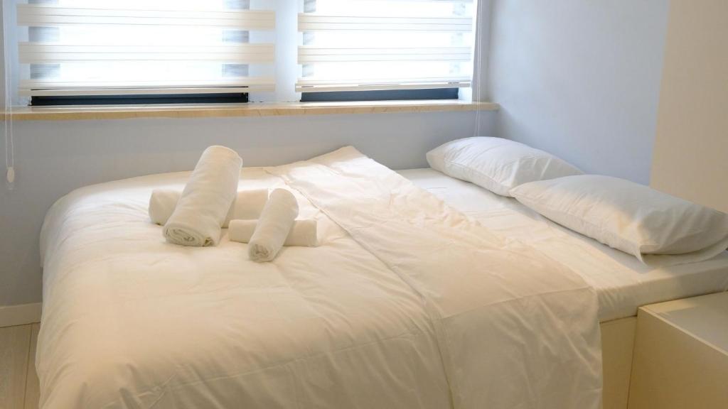 a white bed with two towels on top of it at Rodax Residence in Istanbul