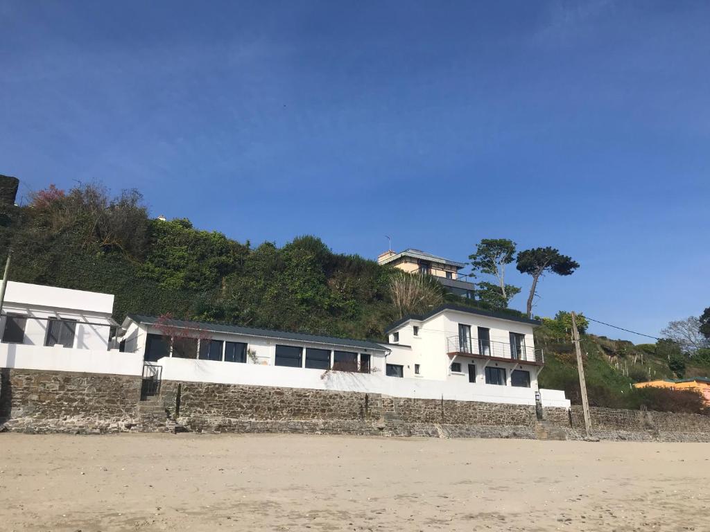 une maison au sommet d'un mur sur la plage dans l'établissement Maison pieds dans l'eau d'exception en Bretagne !, à Plérin