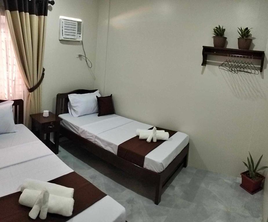 a hotel room with two beds with towels on them at JMorino Pension House in Puerto Princesa City