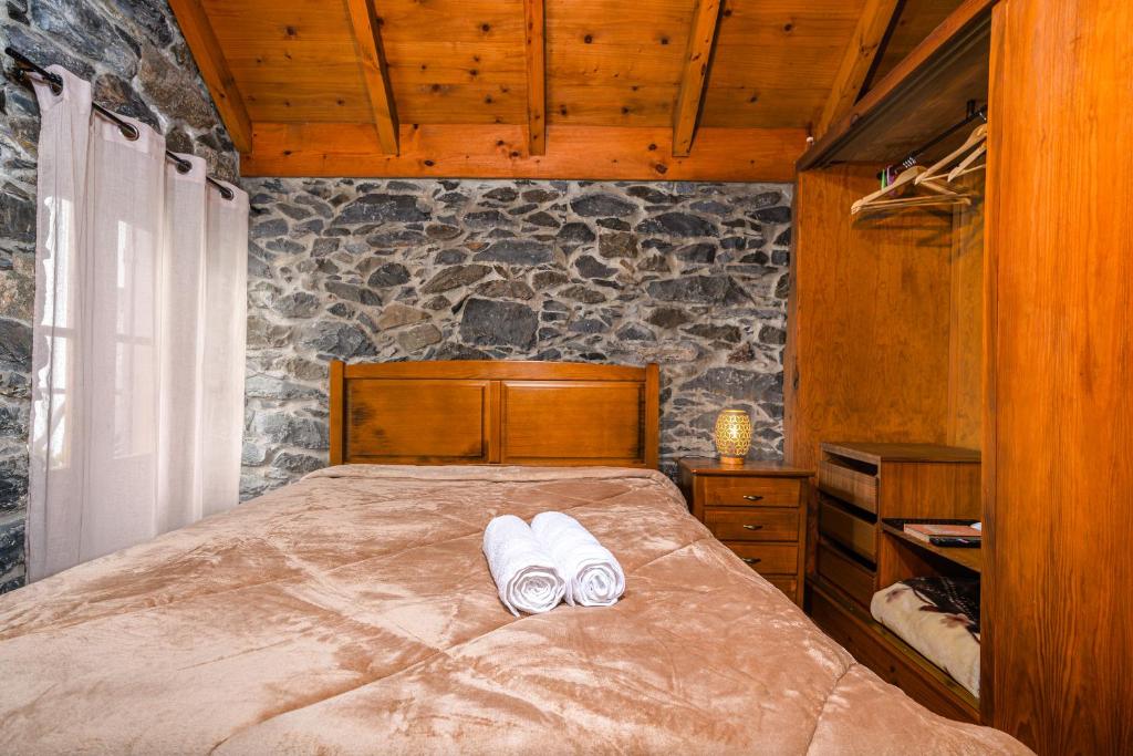 a bedroom with a bed with two towels on it at King's House - Centennial House in Ribeira do Raposo