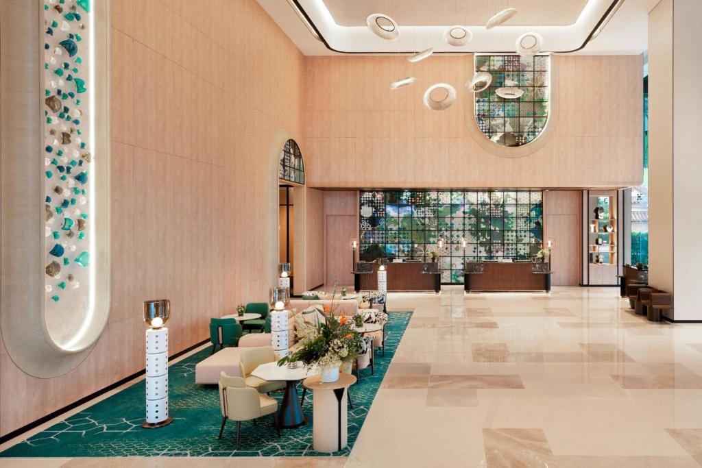 峇六拜Iconic Marjorie Hotel, Penang, a Tribute Portfolio Hotel的酒店大堂里摆放着桌椅