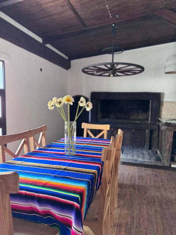 a dining room table with a vase of flowers on it at La Casa de Ignacia in Estación Ramallo