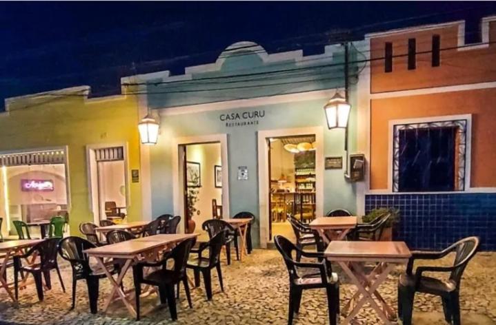 a group of tables and chairs in a restaurant at Casa praiana96 in Paracuru
