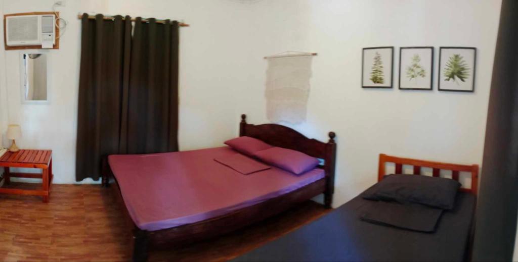Kama o mga kama sa kuwarto sa Lazy Juan Beach House Nacpan