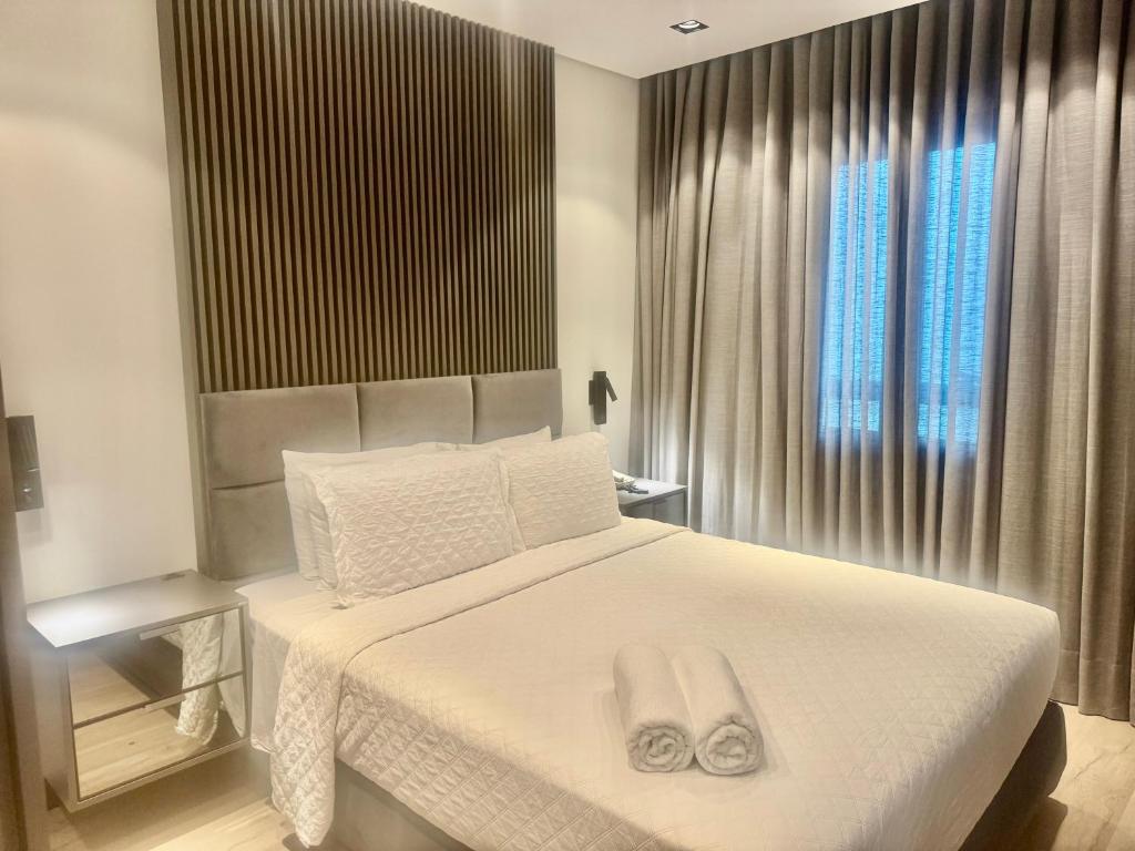 a bedroom with a white bed with two towels on it at Suites in B Tree Av Paulista in Sao Paulo