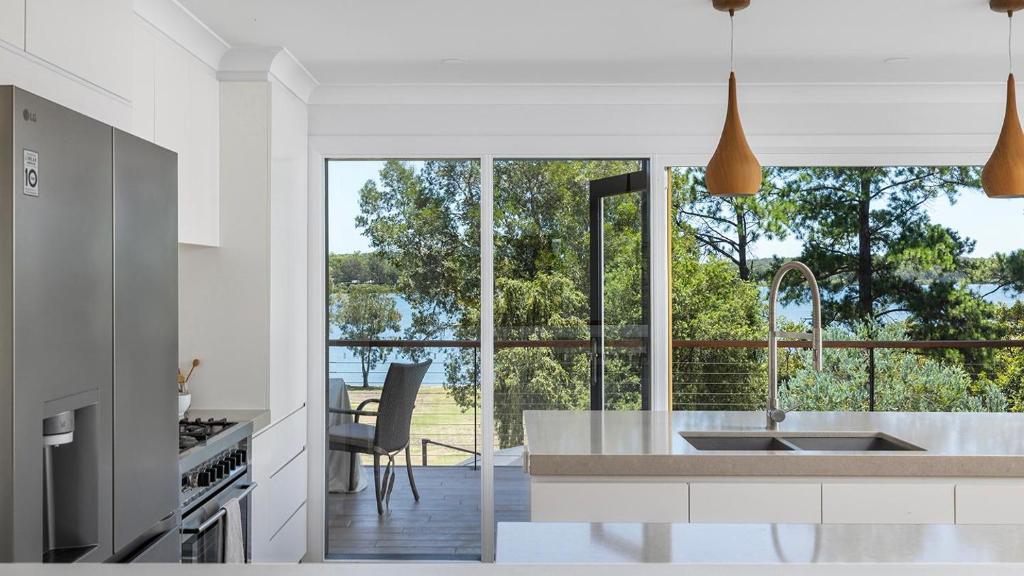 a kitchen with a large window with a view at Rivers Edge Oasis -Karuah, Infinity Pool and Private Cinema room in Karuah