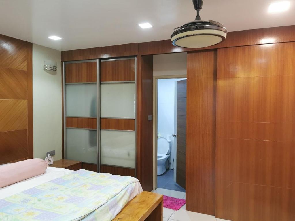 Un dormitorio con una cama y una pared de madera. en A&O HomeKB, en Kota Bharu