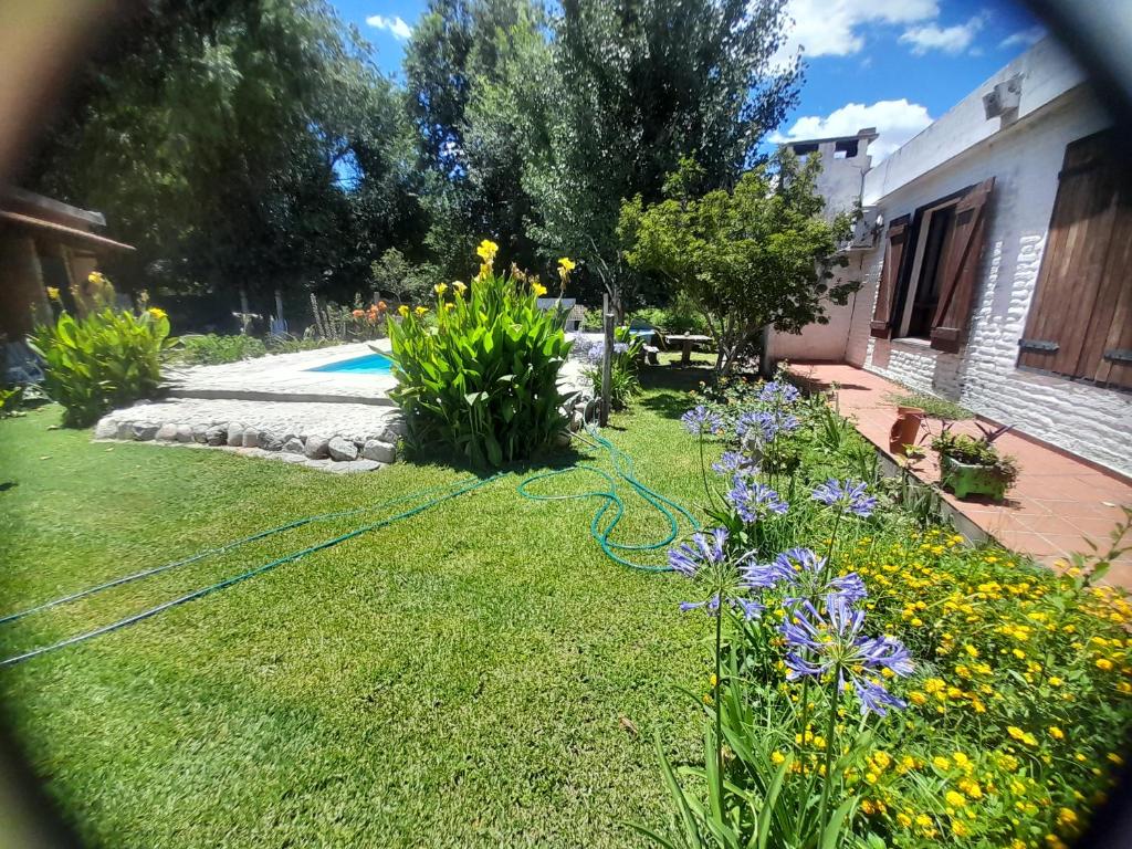 a garden with a hose in the grass at Cabañas Tres Ríos Vacacional in Villa Cura Brochero