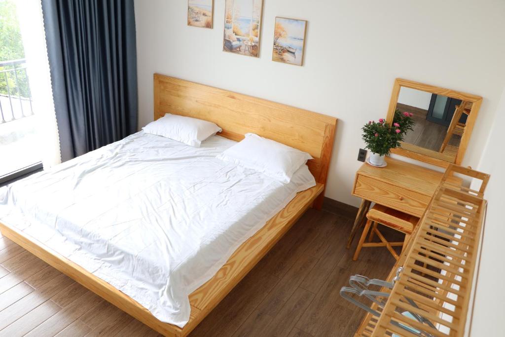 a bedroom with a bed and a table and a mirror at Chiri House in Khu Chi Lăng