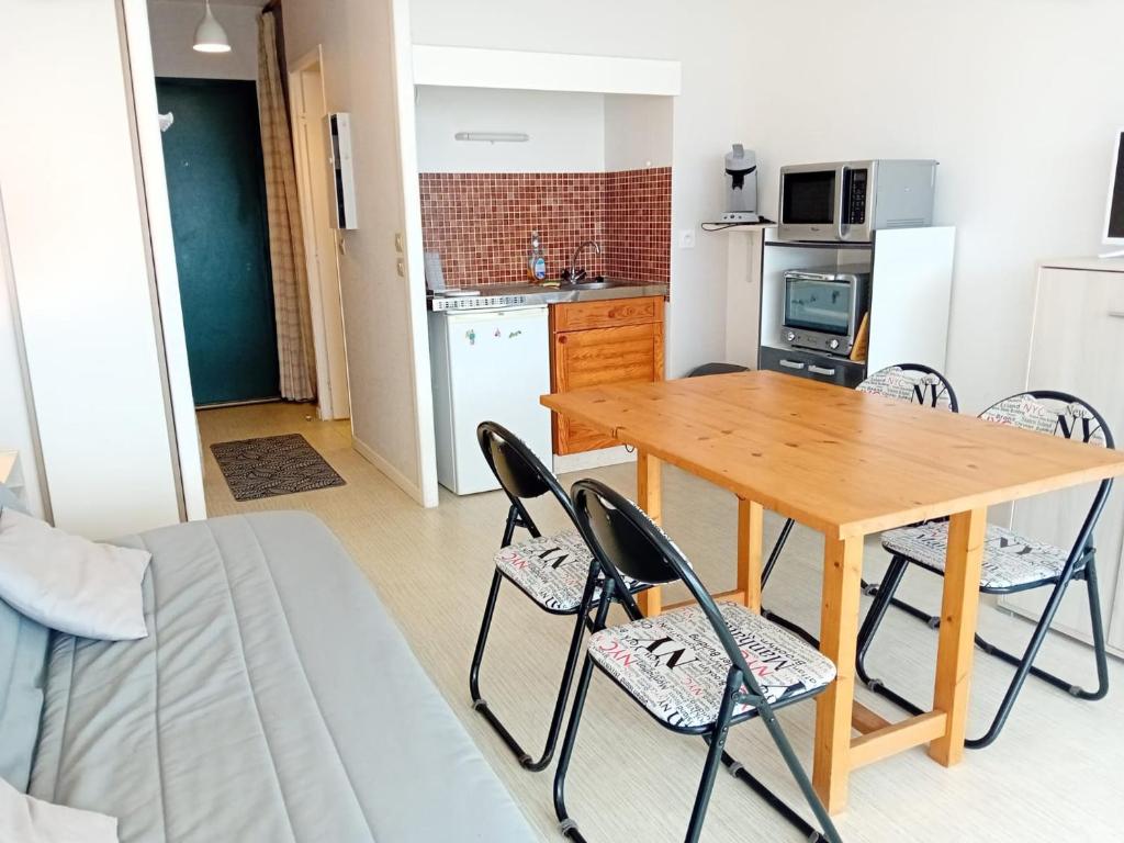 une cuisine et une salle à manger avec une table et des chaises en bois dans l'établissement Studio avec terrasse et parking à deux pas des plages - FR-1-239-563, à Capbreton
