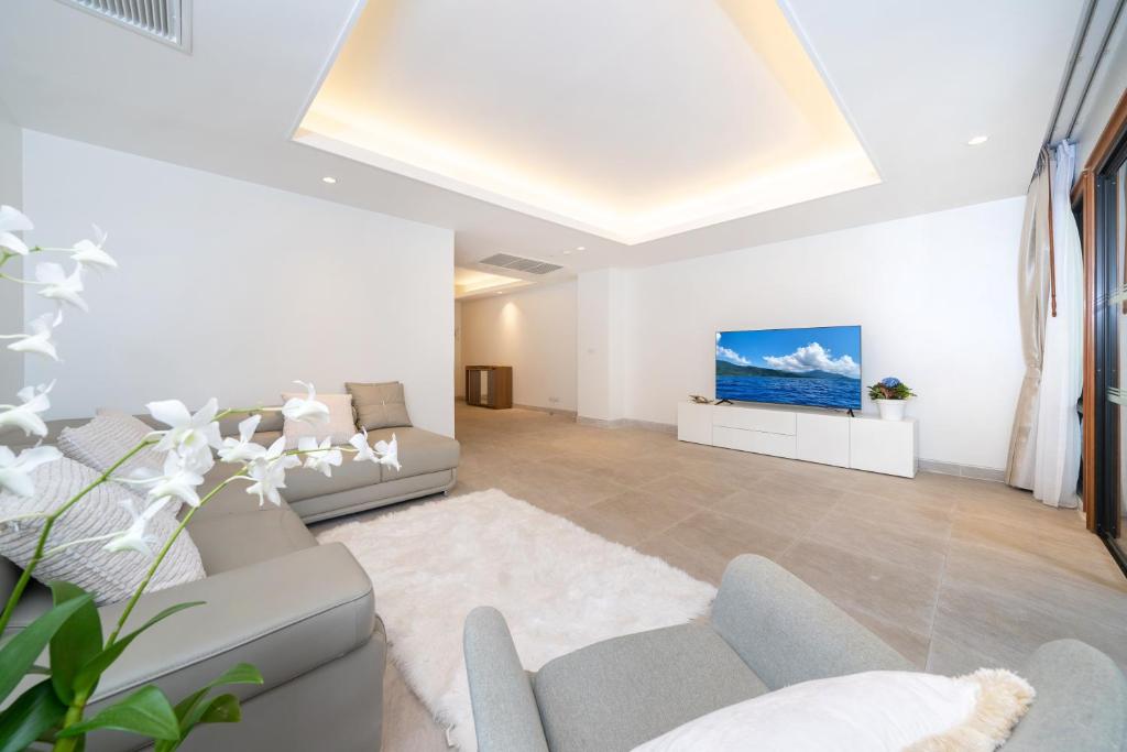 a living room with a couch and a tv at Luxury 2 Bedrooms Villa Bangtao in Ban Pa Khlok