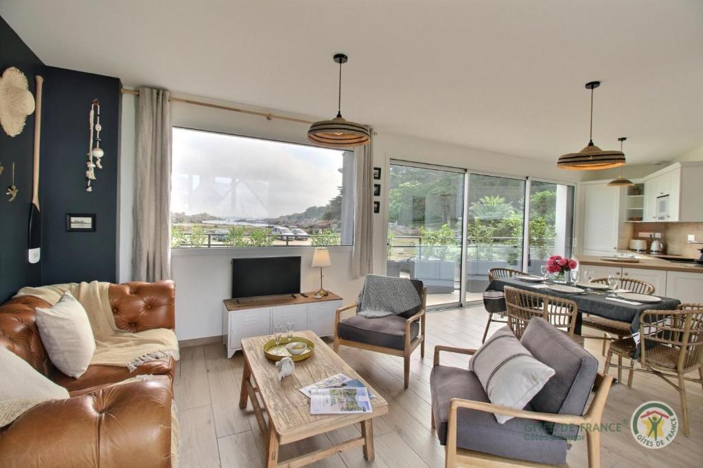 un salon avec un canapé et une table dans l'établissement Ker touro, à Trégastel