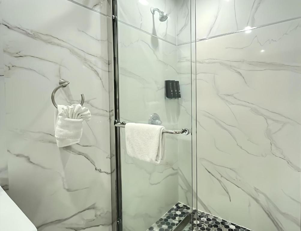 a bathroom with a shower with a glass door at Inn By the Bay Monterey in Monterey