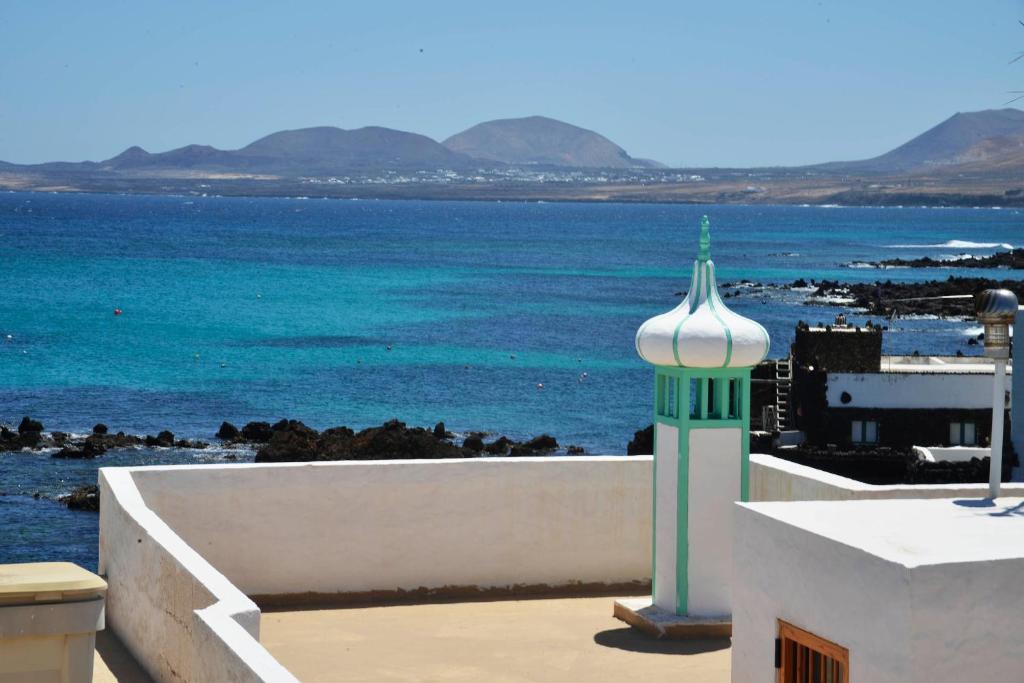 um edifício com uma torre verde e branca junto ao oceano em Casa Chanin em Punta Mujeres