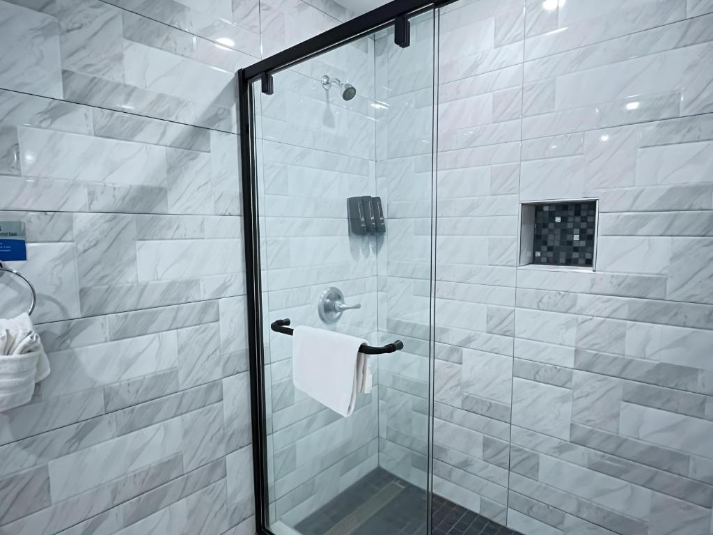 a bathroom with a shower with a glass door at Inn By the Bay Monterey in Monterey
