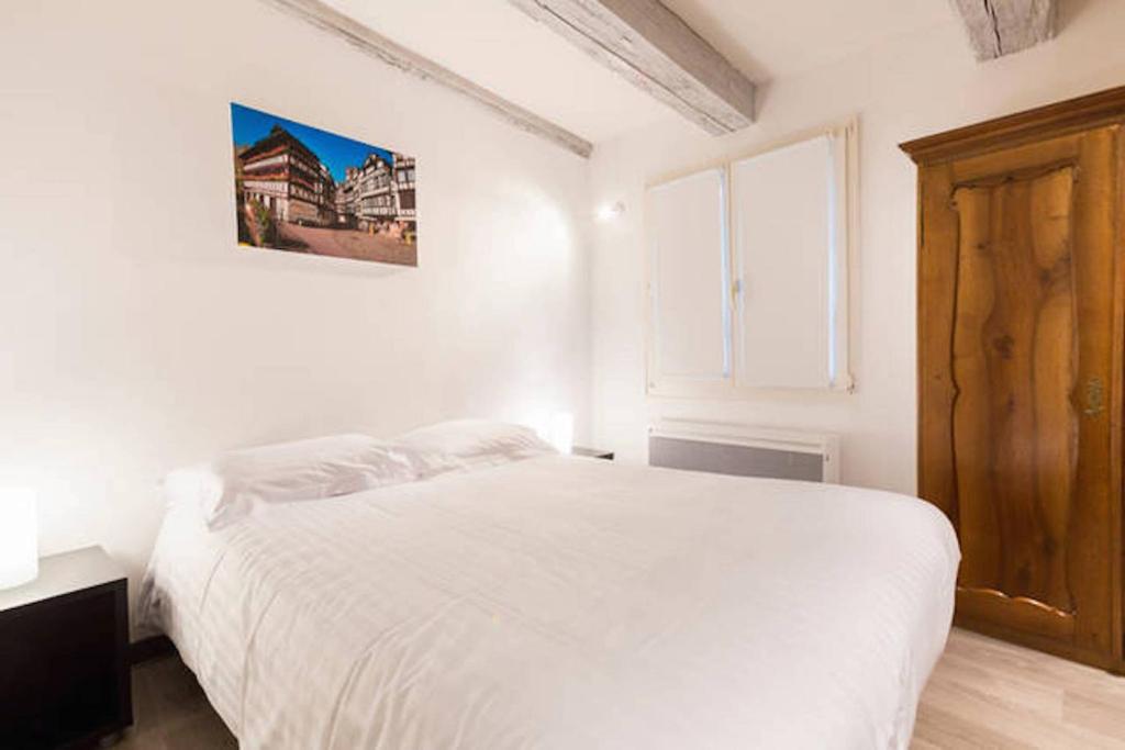 a bedroom with a white bed and a window at COLMAR city center Little Venise - GITE DE LEA - in Colmar