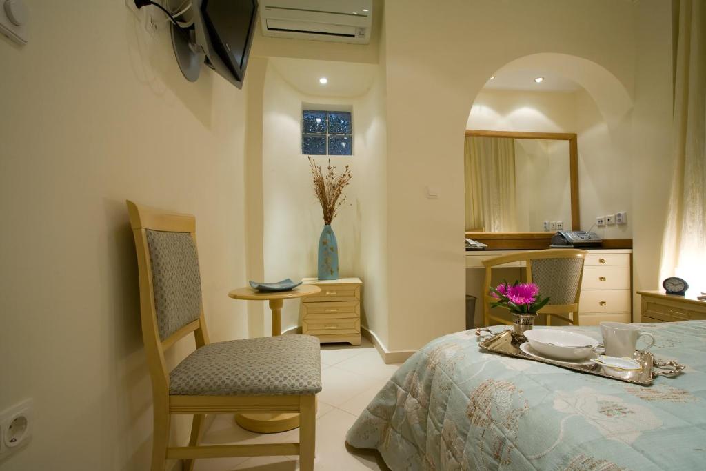 a bedroom with a bed and a table and chairs at Andria Suites in Andros