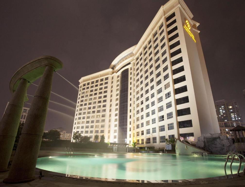 a large building with a pool in front of it at Parklane Hotel Changan in Dongguan