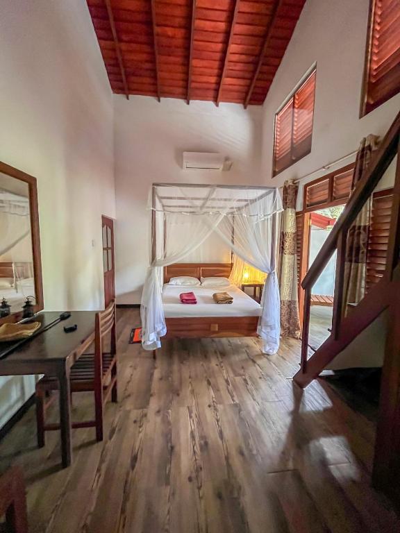 una camera con letto, scrivania e tavolo di Abraham Beach House a Tangalle