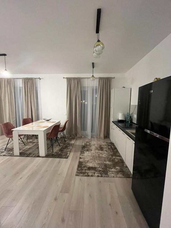 a living room with a kitchen and a dining room table at Ioanic Modern Apartment with Parking in Ploieşti