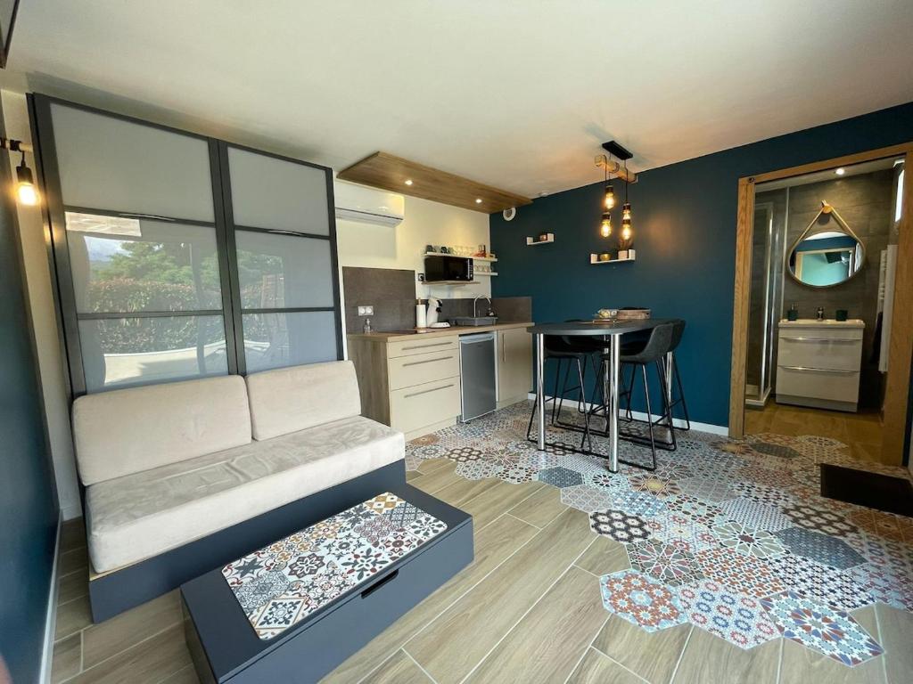 un salon avec un canapé et une cuisine dans l'établissement Neuf, indépendant avec terrasse et vue montagnes !, à Cruet