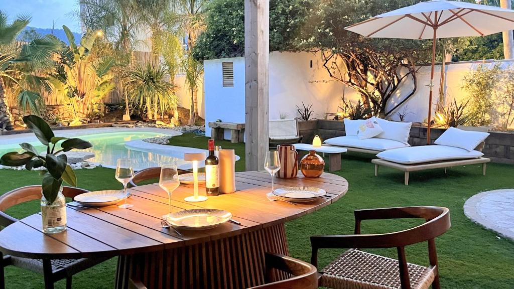 - une table en bois avec des verres à vin sur la terrasse dans l'établissement Tim by Terrys Homes, à Hyères