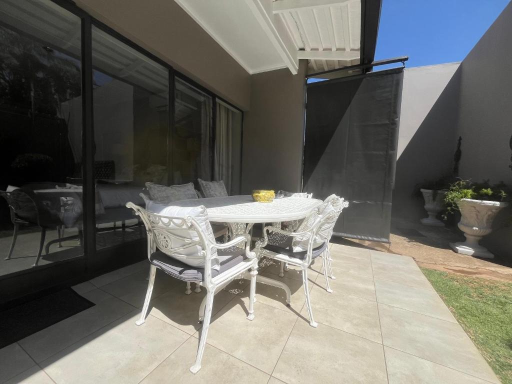 a white table and chairs on a patio at La Vida Luka - Luxury Guesthouse in Pretoria