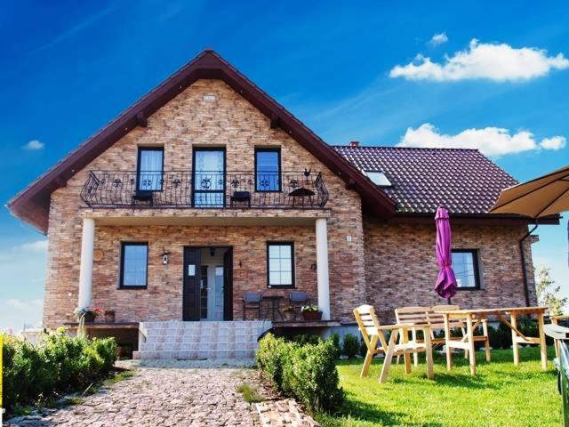 a brick house with a table and chairs in front of it at Villa Polskacanaria in Gardeja