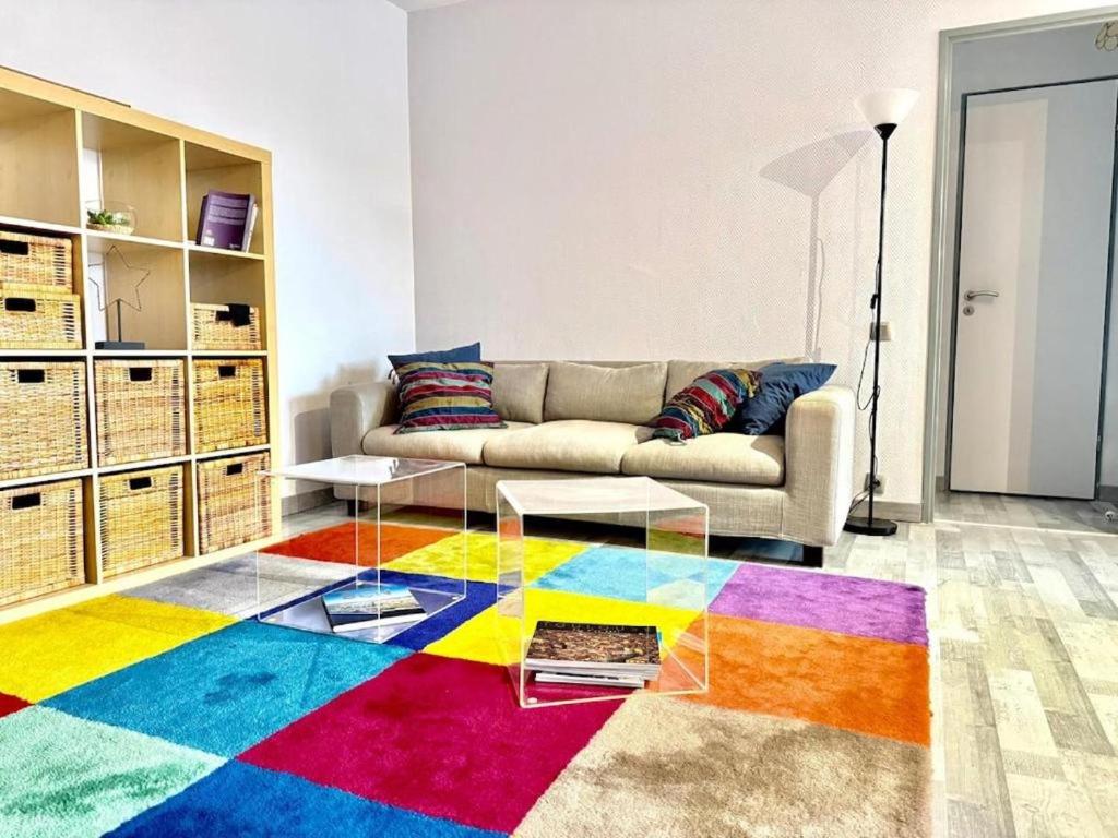 - un salon avec un canapé et un tapis coloré dans l'établissement Vidal by Yumē, à Toulouse
