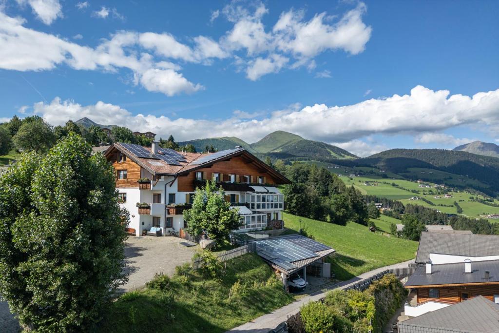 an aerial view of a house with mountains in the background at Residence Rastbichl - Apartments & Indoor-Pool in Maranza