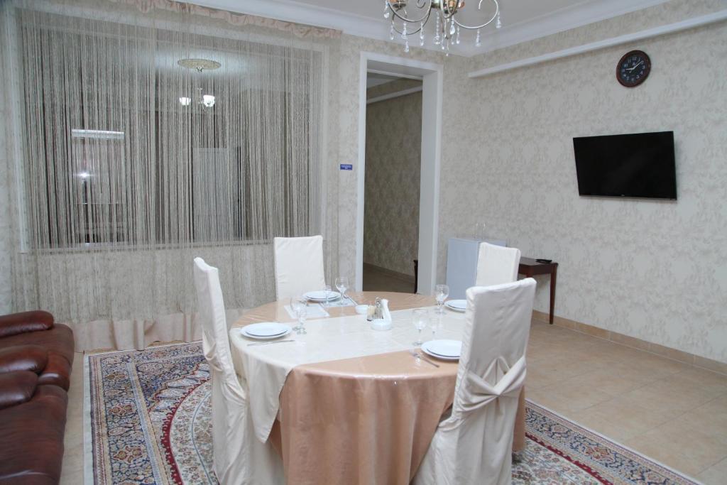 a dining room with a table and chairs and a television at Inn Kavkaz in Makhachkala