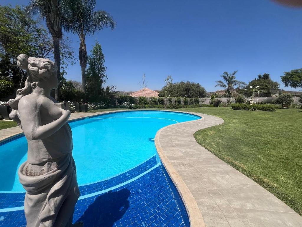 a statue of a woman standing next to a swimming pool at La Vida Luka - Luxury Guesthouse in Pretoria