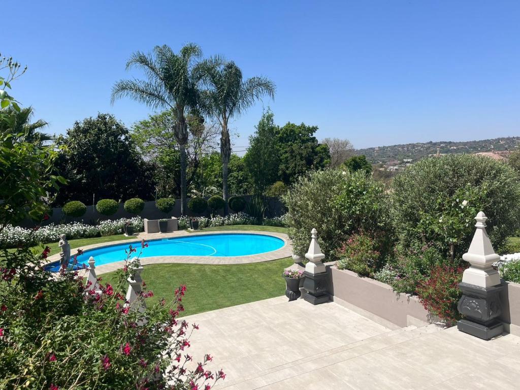 a garden with a swimming pool and trees at La Vida Luka - Luxury Guesthouse in Pretoria