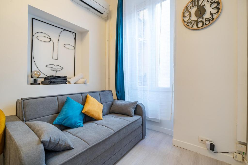 un salon avec un canapé et une horloge au mur dans l'établissement Superbe Studio Clim hyper-centre, à Nice