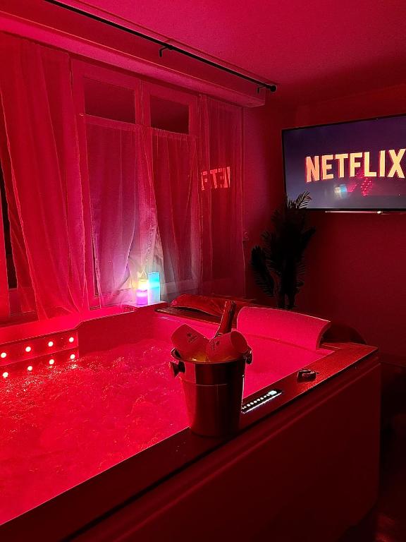 une chambre rouge avec une baignoire remplie de teinture rouge dans l'établissement Romantic Room - Jaccuzi Privé -Appartement Cannes, à Cannes