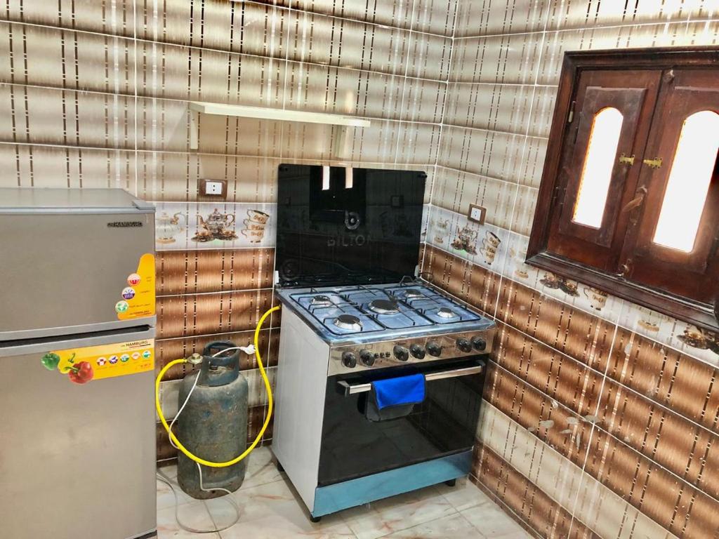 a kitchen with a stove and a refrigerator at Pyramid Siwa in Siwa